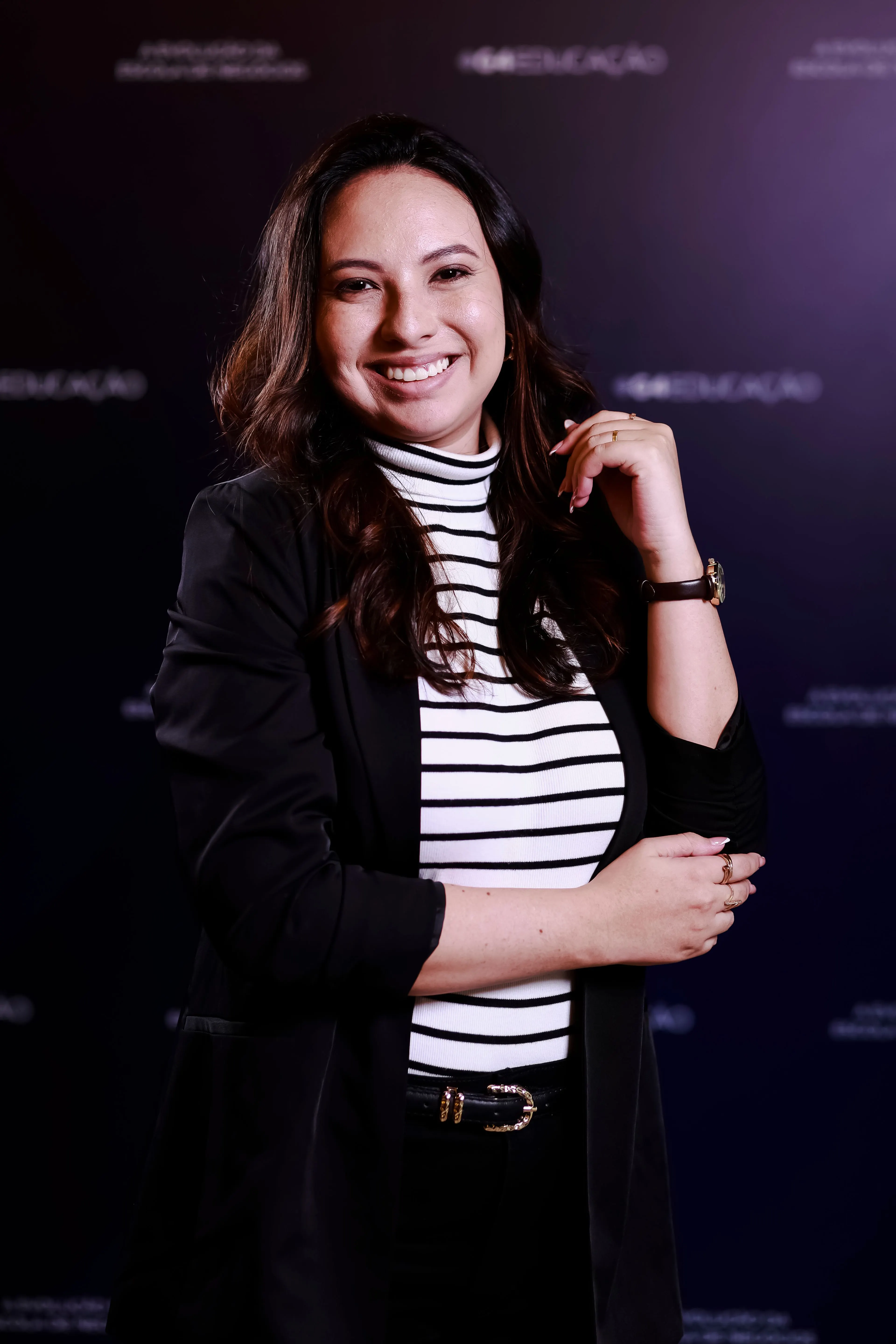 Gabrielly Reis sorrindo, de blazer preto e blusa listrada